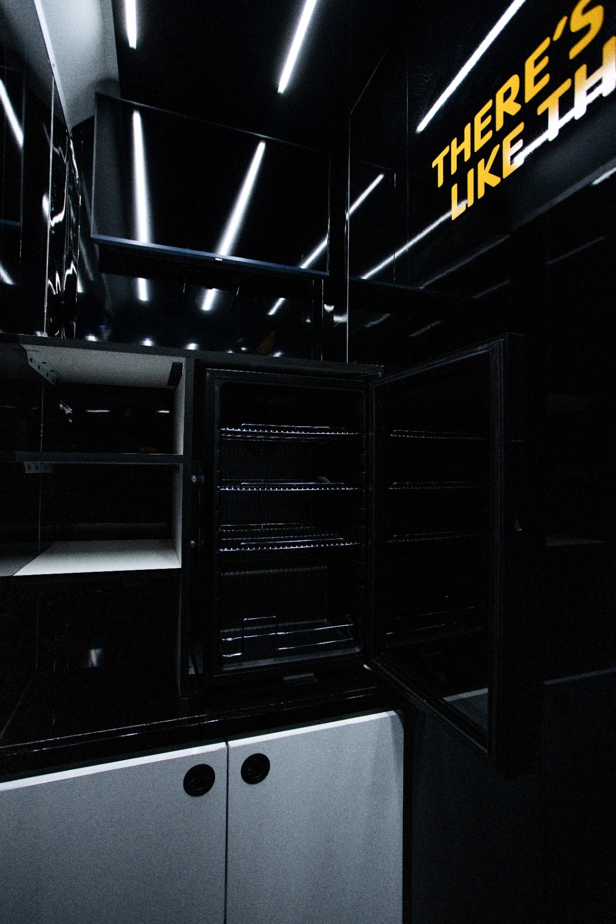 Fit Truk interior with a wall-mounted display, open refrigerator and storage cabinets