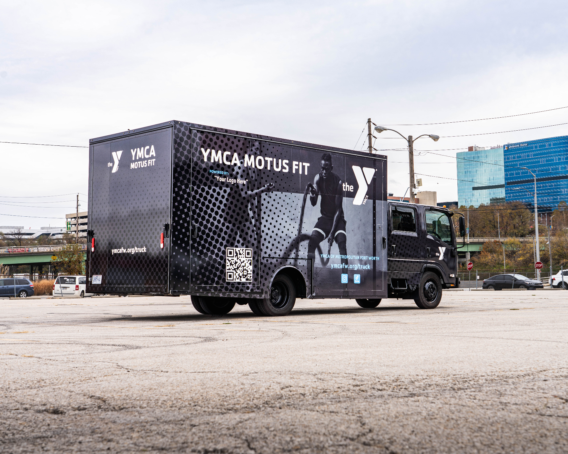 Rear three-quarter view of the closed YMCA of Metropolitan Fort Worth Fit Truk parked in a lot