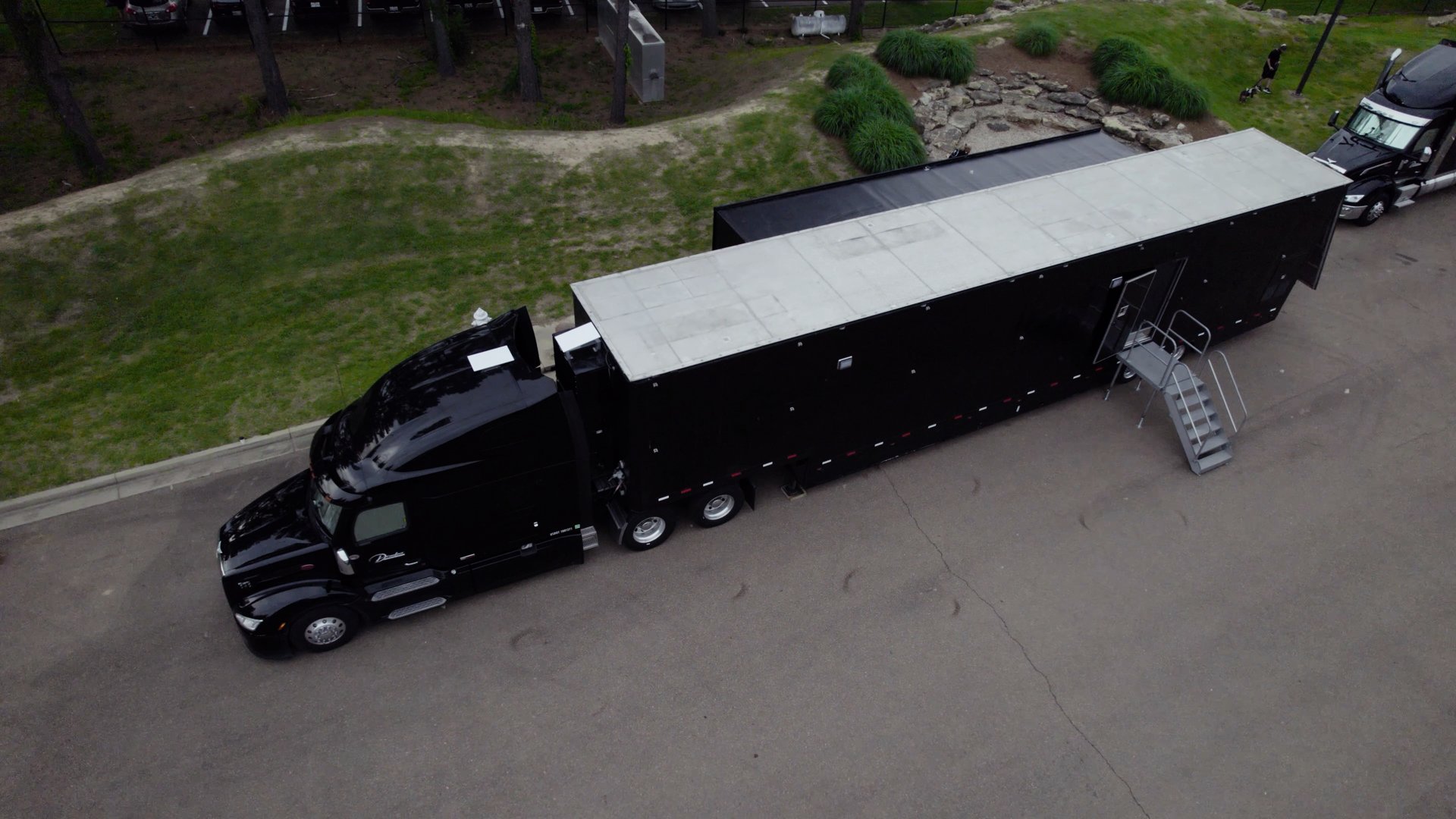 Black custom gym trailer and towing vehicle, viewed from above