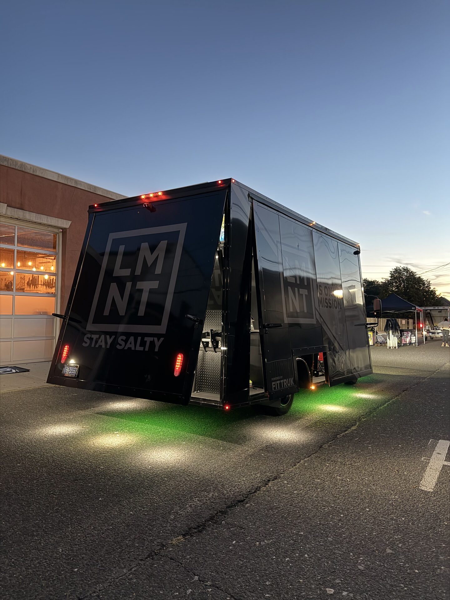 LMNT-branded Fit Truk at dusk with green underglow