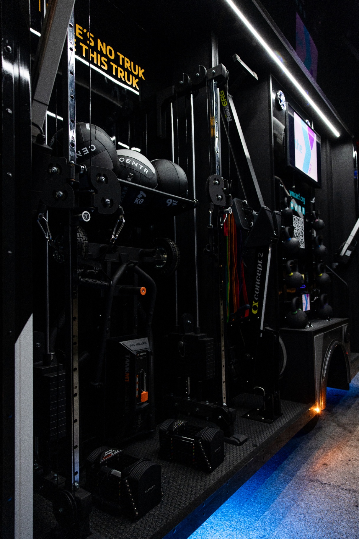 Side training bay with cable towers, medicine balls, dumbbells and a Concept2 machine