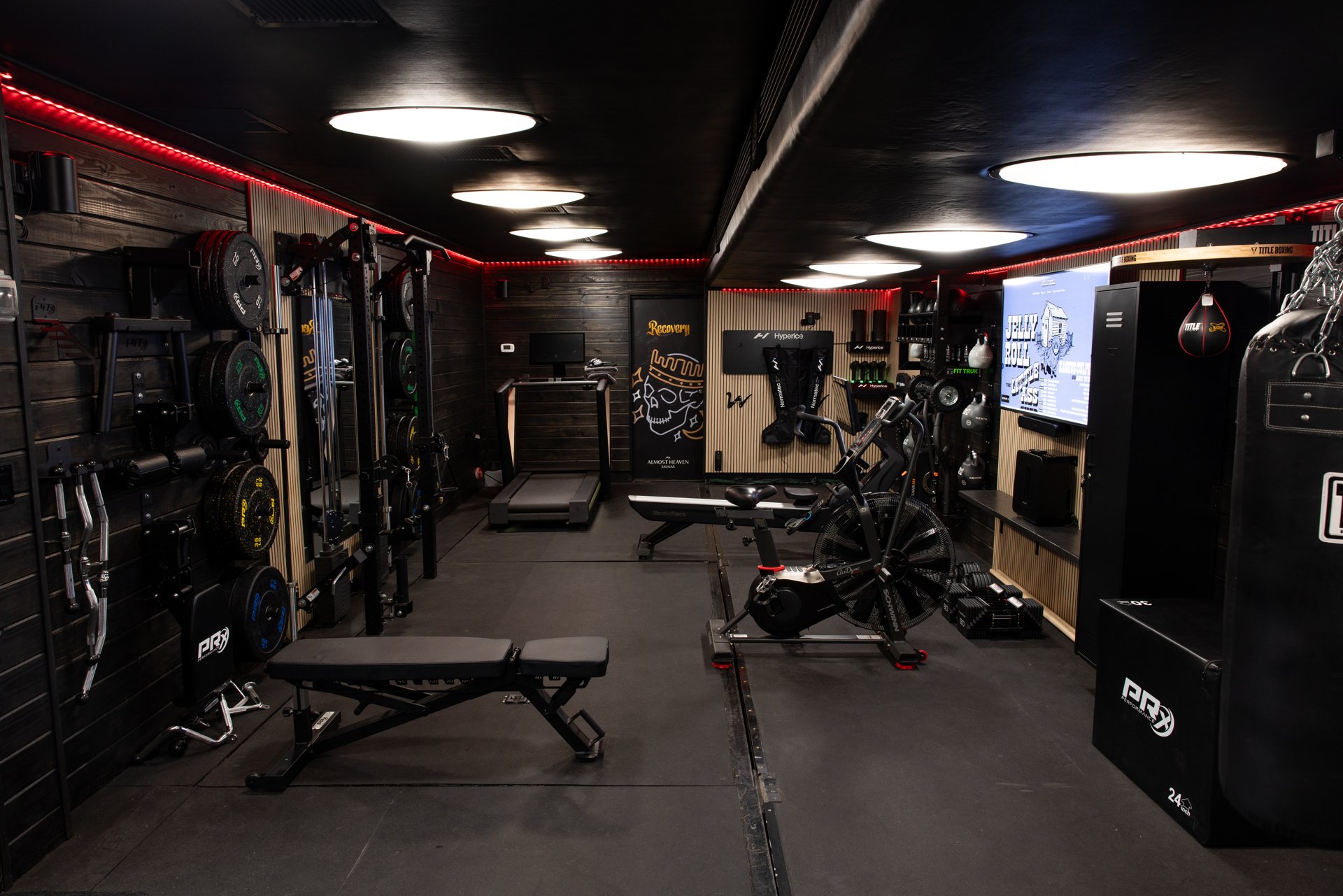 Custom gym trailer interior with training equipment, storage and red ceiling lighting
